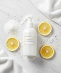 Cosmecell Brightening Body Lotion - radiant flat lay with kojic acid and citrus elements